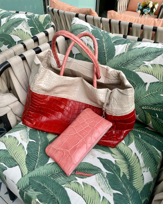 Red and white handbag with a matching wallet on a leaf-patterned surface