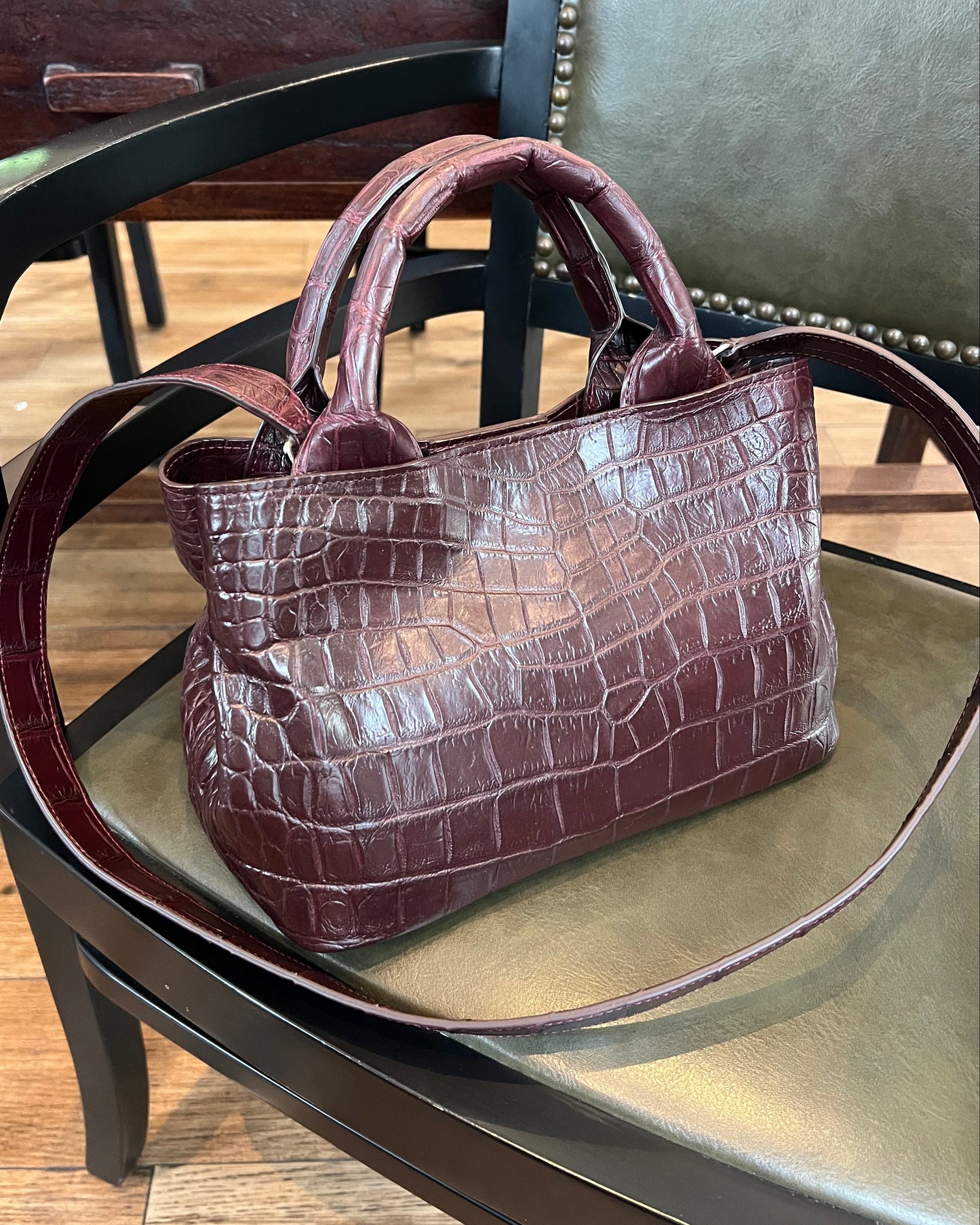 Brown crocodile-patterned handbag on a chair