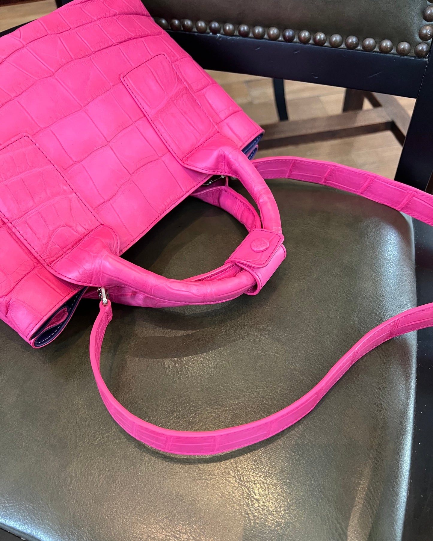 Pink handbag on a dark chair