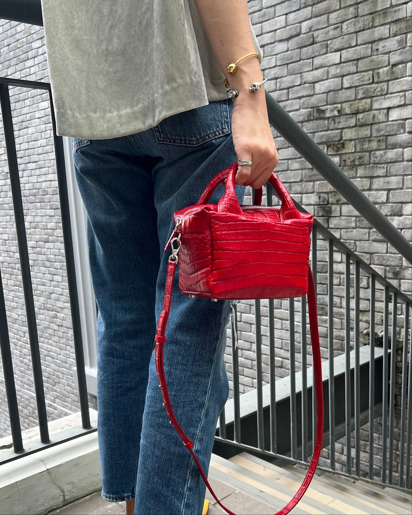 Person holding a red handbag on a staircase
